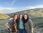 Young women pose with Reid Ranch's plateau in the background.